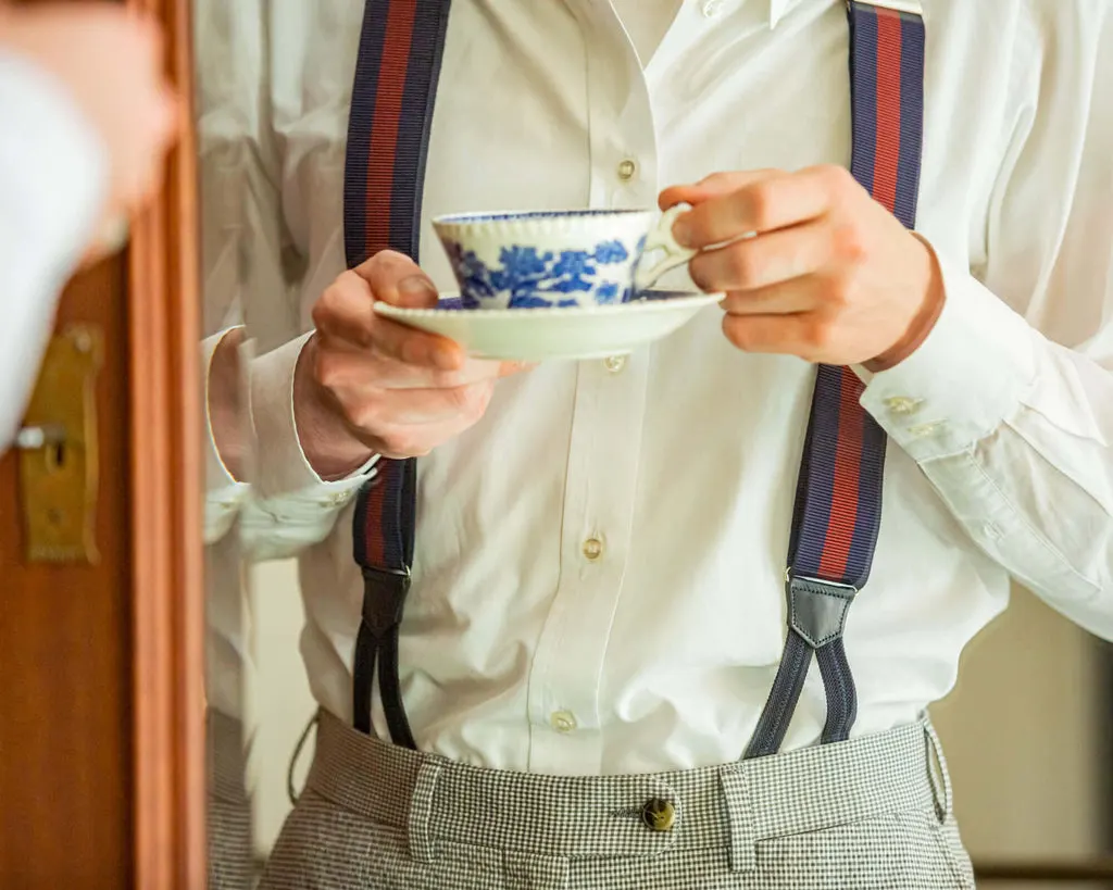 Herr von Welt mit Hosenträgern aus dem Shop und einer Tasse Tee